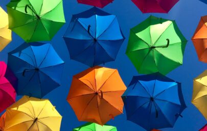 Krāsaini lietussargi zilās debesīs